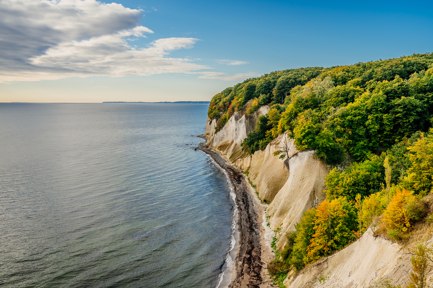 Blick entlang der Kreideküste im Nationalpark Jasmund auf Rügen mit Herbstwald, Ostsee und hellem Himmel. Blick entlang der Kreideküste im Nationalpark Jasmund auf Rügen mit Herbstwald, Ostsee und hellem Himmel.