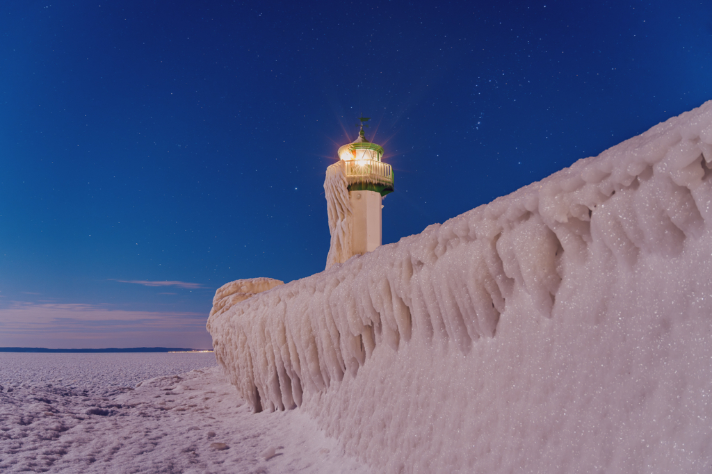 Sassnitzer Mole im Eiswinter bei Nacht: vereiste Mole mit Leuchtfeuer und gefrorener Ostsee