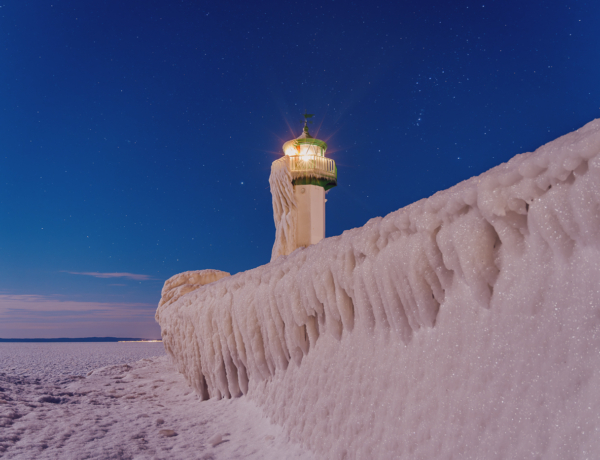 Sassnitzer Mole im Eiswinter bei Nacht: vereiste Mole mit Leuchtfeuer und gefrorener Ostsee