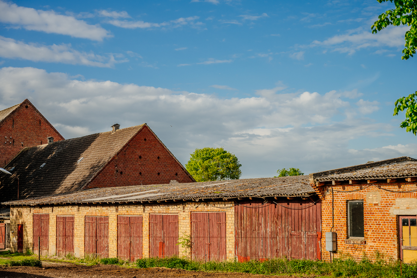 Reihe alter Wirtschaftsgebäude und Schuppen mit roten Holztoren in Holzendorf.