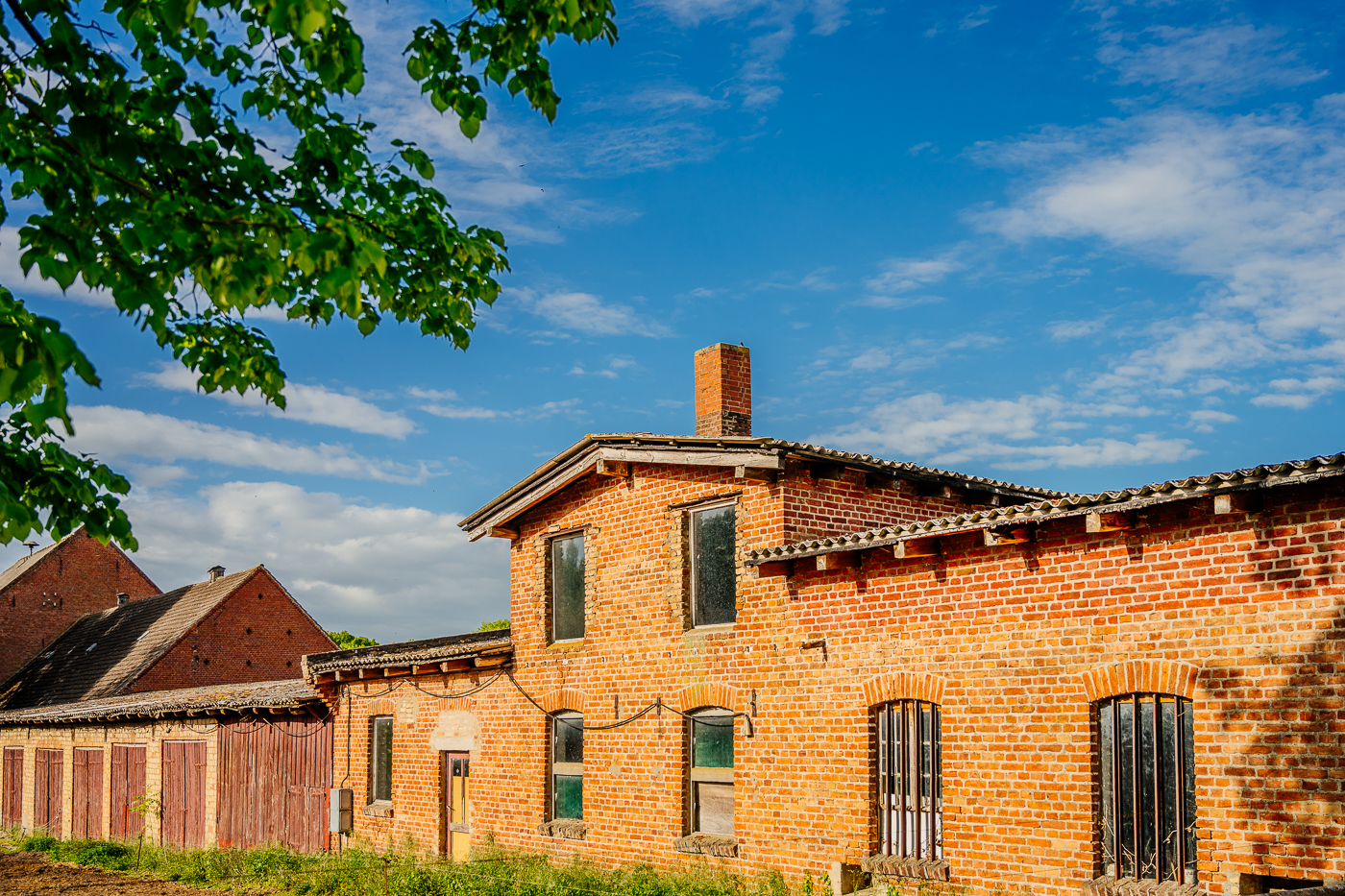 Alte Backsteinbauten mit Türen und vergitterten Fenstern auf dem Landwirtschaftsgelände in Holzendorf.