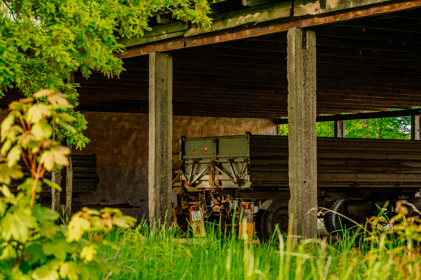 Landwirtschaftlicher Anhänger unter einem offenen alten Wirtschaftsgebäude in Holzendorf.