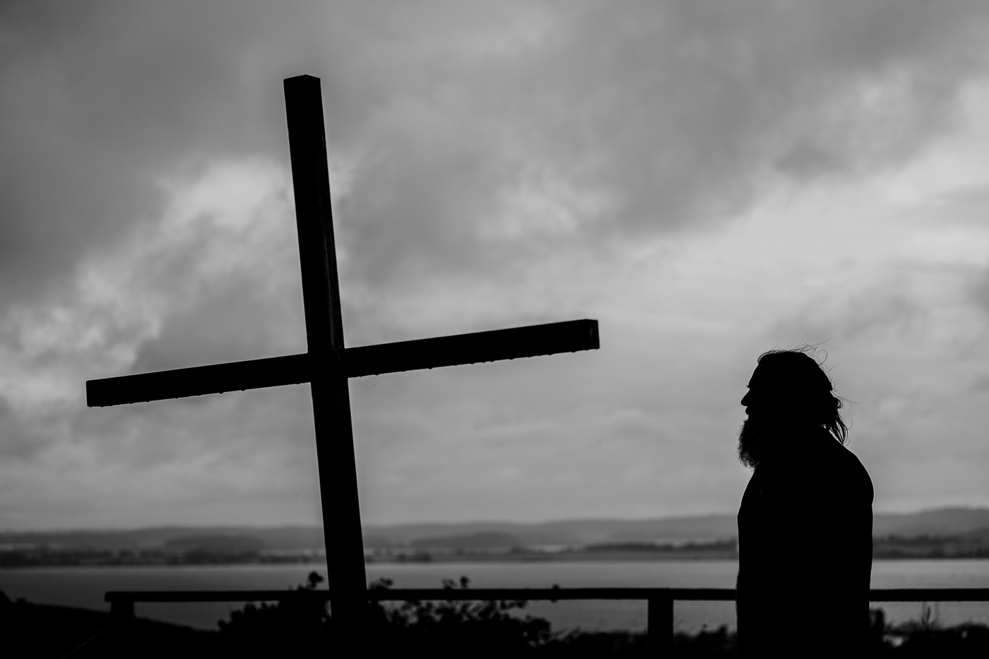 Silhouette von Frank Westphal neben dem Kreuz am Bakenberg bei Groß Zicker, dahinter die Landschaft des Mönchguts.