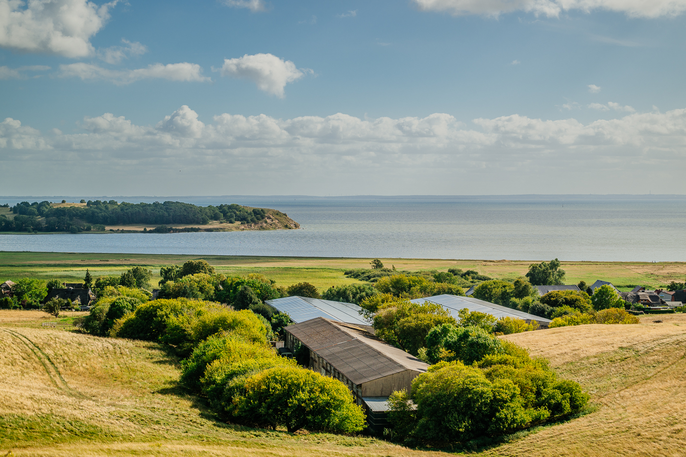 Blick von den Zickerschen Bergen auf den Pommernhof Westphal bei Groß Zicker mit Stalldächern, Feldern und Greifswalder Bodden.